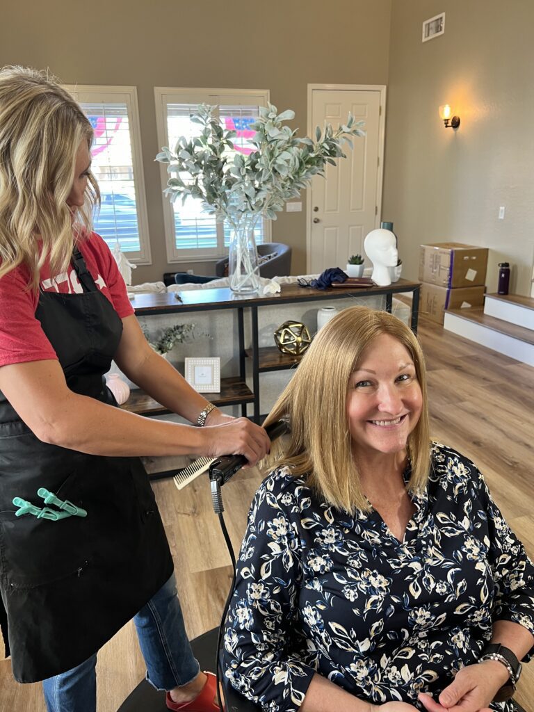 woman and her hair stylist curling her custom wig